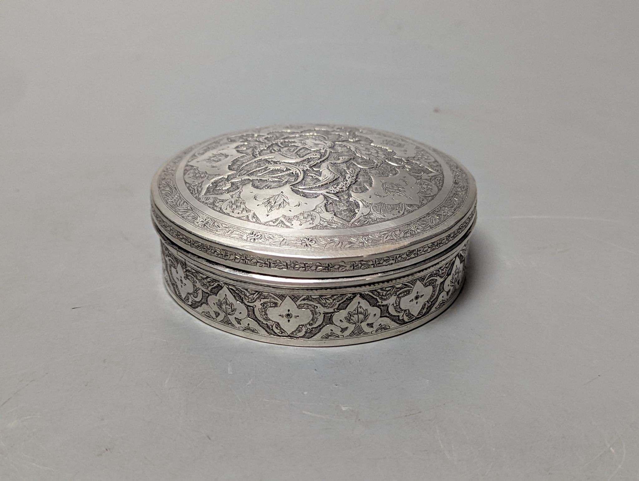 A Persian engraved white metal circular box and cover, 86mm